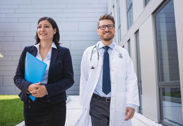 Smiling doctors walking together in hospital premises