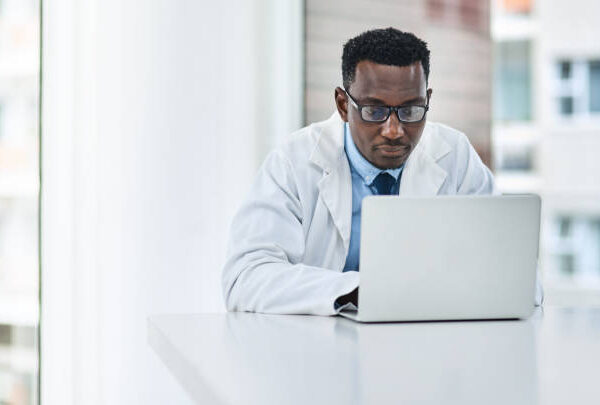 Shot of a young doctor using a laptop at his desk